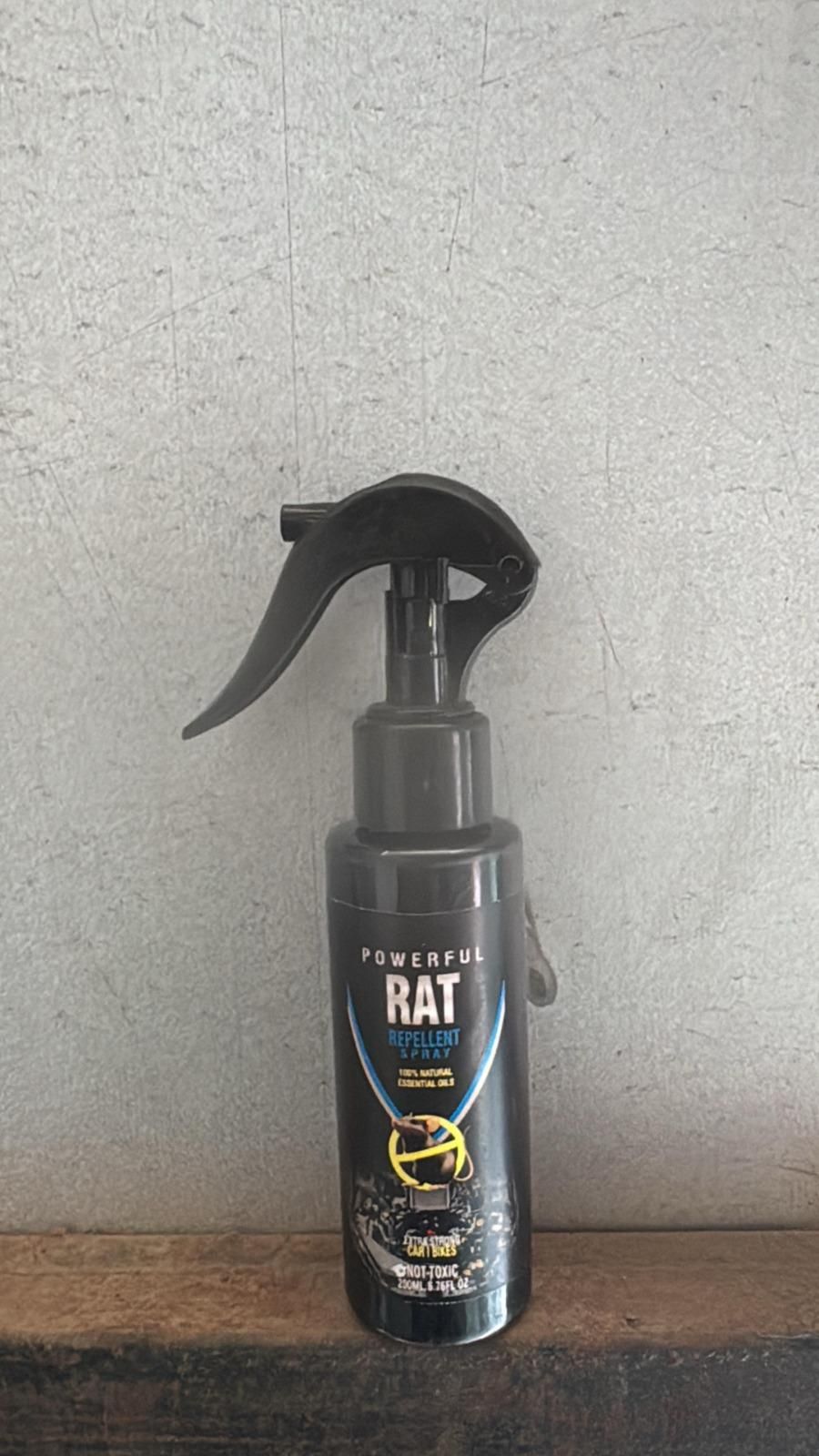 Spray bottle labeled 'Powerful Rat' on a textured surface